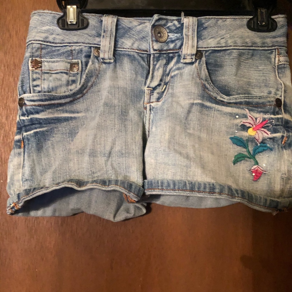 Denim shorts. Flowers on front and back pockets